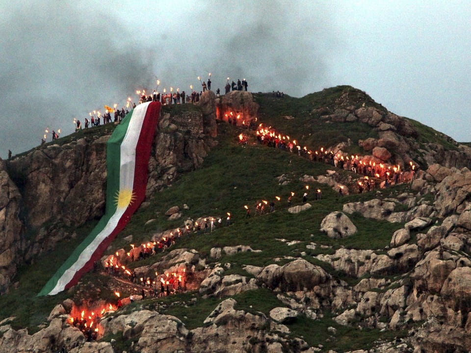 Eine lange Fahne in Grün-Weiss-Rot auf einem Berg.