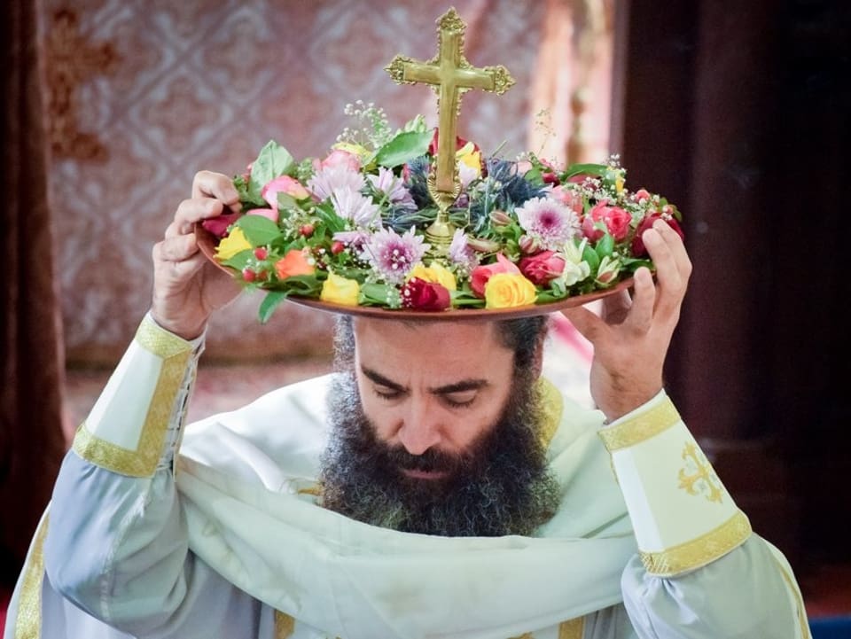 Ein orthodoxer Kirchenvertreten mit Blumenhut.