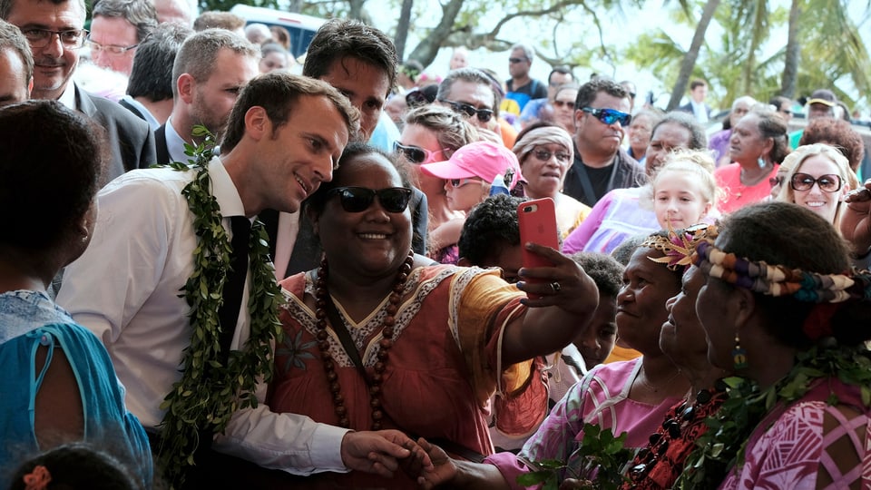 Macron macht Selfies mit Menschen in Neukaledonien.