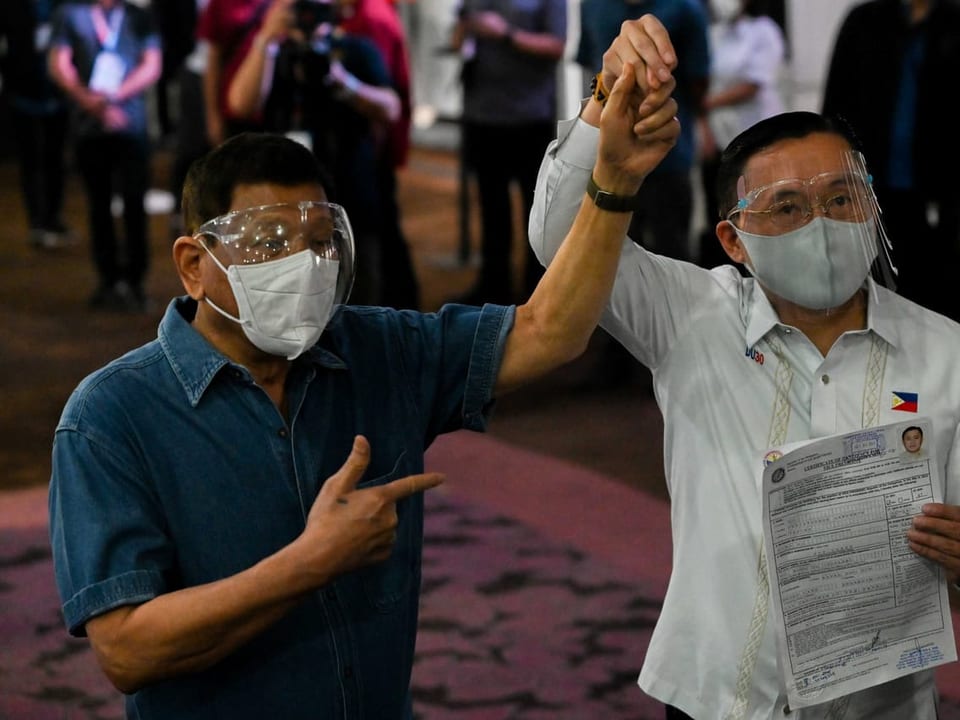 Duterte links hebt die Hand von Go rechts, um die Unterstützung zu bekunden.