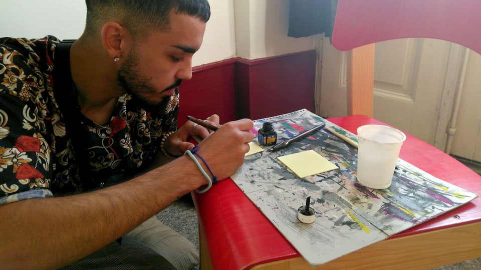 Ein junger Mann zeichnet ein Bild.