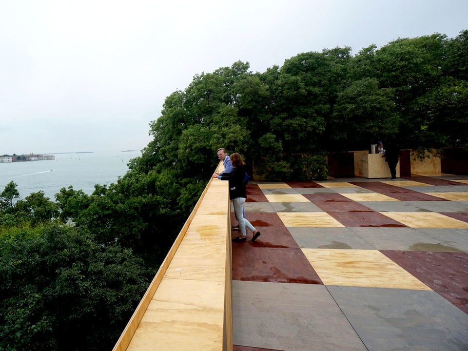 Zwei Menschen stehen auf einer Terrasse.