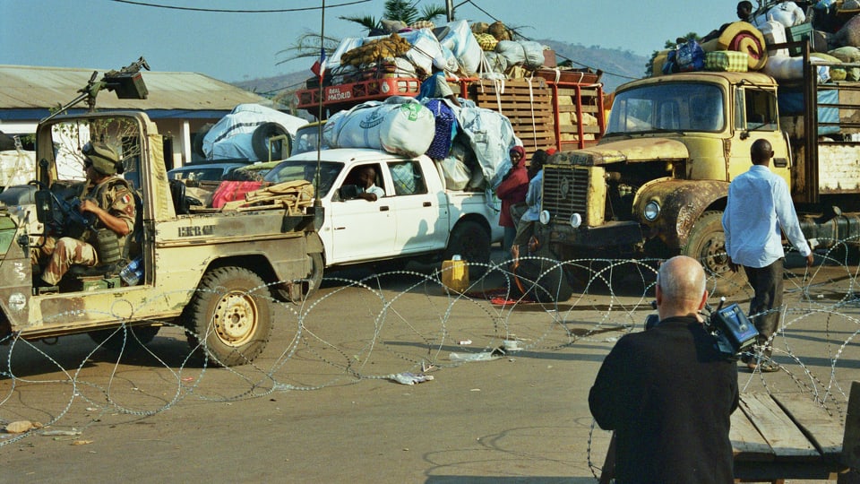 Überladene Autos und Trucks in einer afrikanischen Gegend.