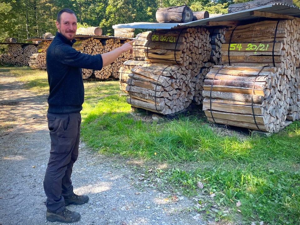 Renato Stracka steht vor einem Stapel mit Brennholz