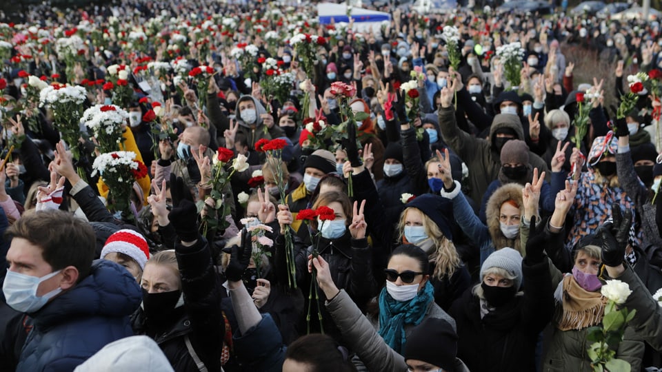 Hunderte Personen versammeln sich anlässlich der Beerdigung von Demonstrant Roman Bondarenko und machen zum Zeichen des Protests das Friedenszeichen