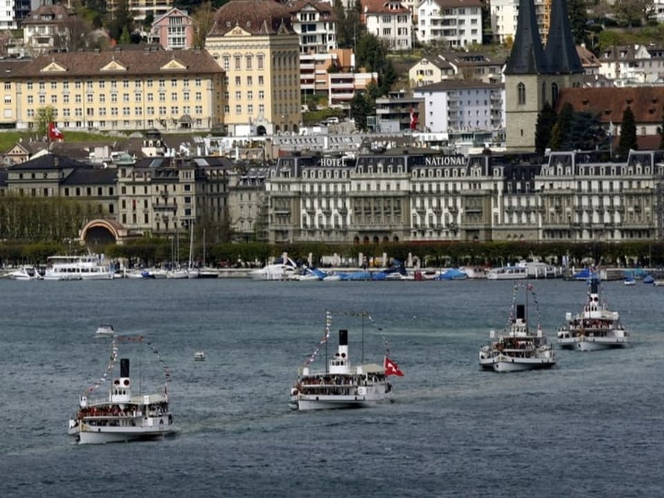 Vier Dampfschiffe fahren durch das Luzerner Seebecken.