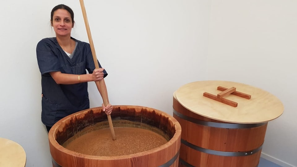 Caroline Kulangara rüht ihre Sojasauce in grossen Holzfässern