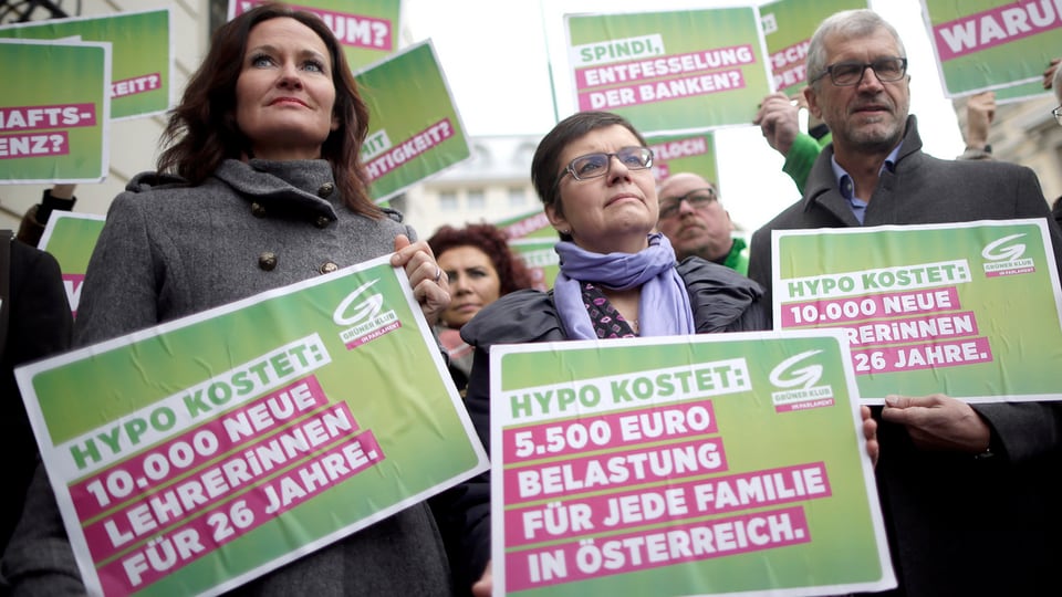 Parteimitglieder mit grünen Plakaten gegen die Hypo-Pleite.