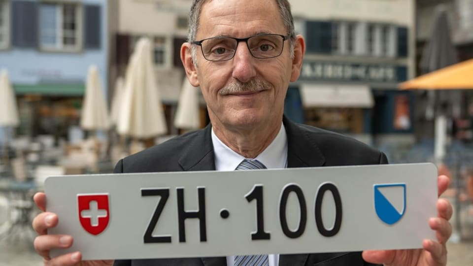 Regierungsrat Mario Fehr hält Kontrollschild ZH 100 hoch.