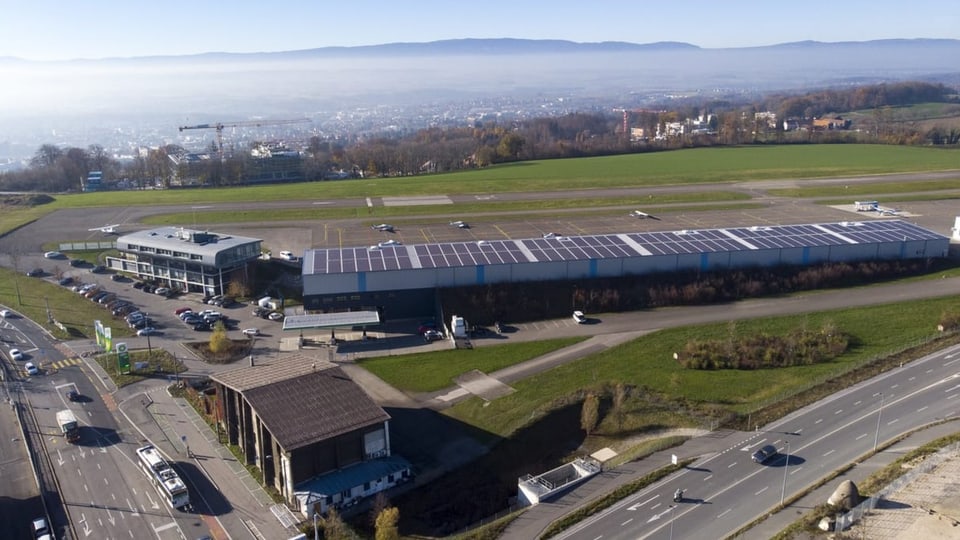 Der Flughafen ist von Oben zu sehen. Die Rollbahn ist leer – kein Flugzeug ist zu sehen.