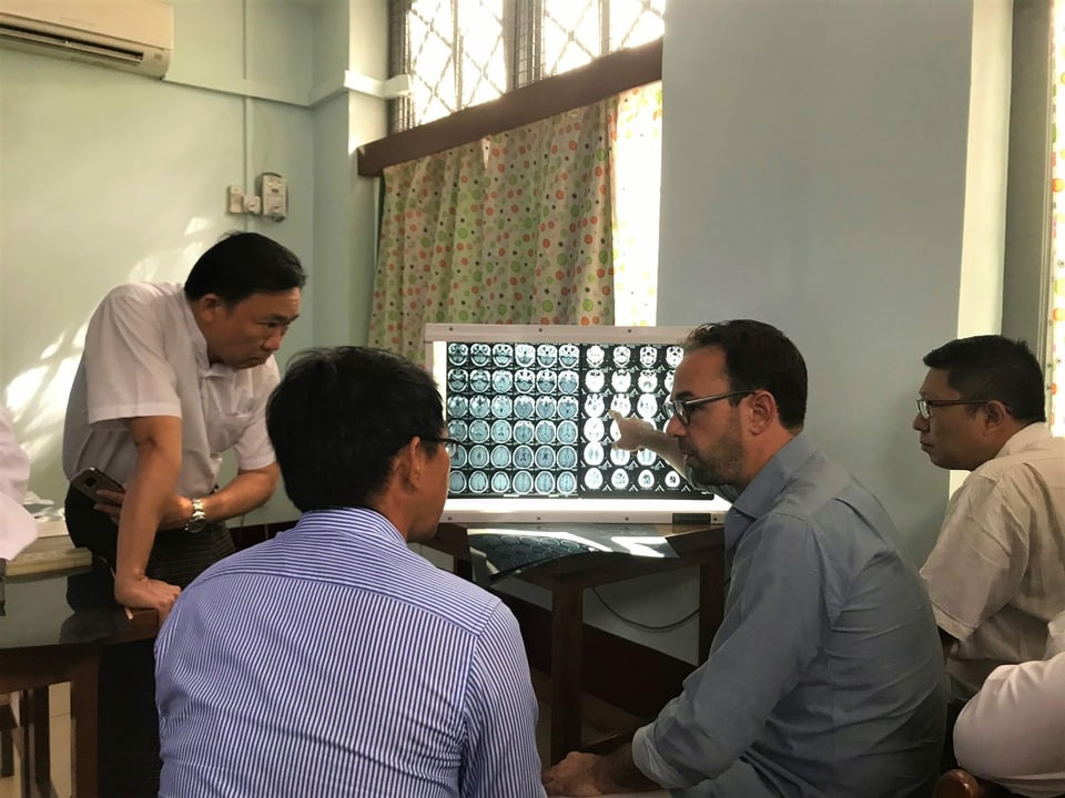 Arztkollegen sitzen in Burma mit Philippe Schucht vor einem Bildschirm und besprechen einen Fall.