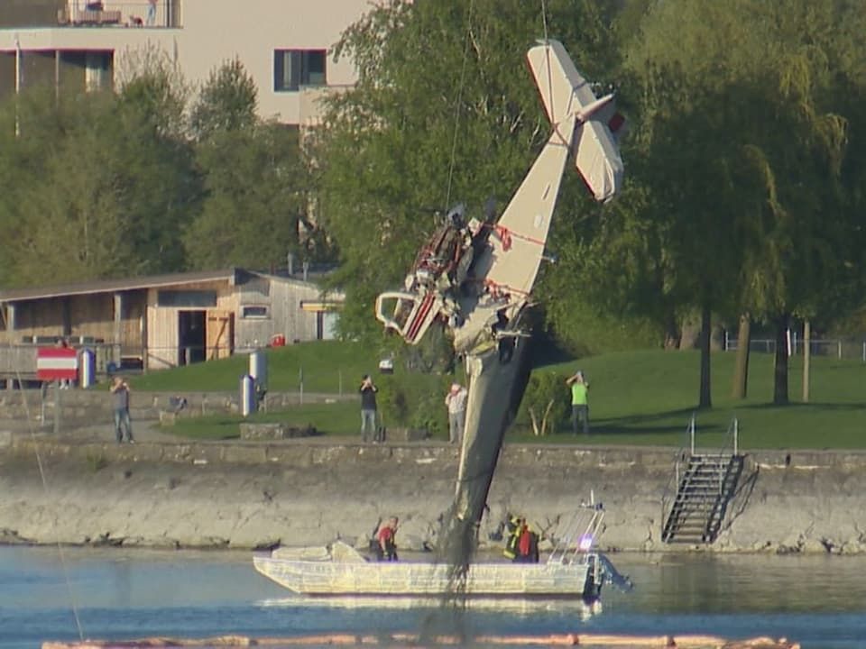 Ein Helikopter zieht das Flugzeug aus dem See.