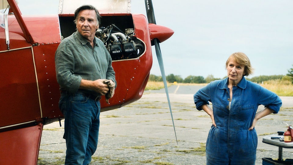 Ein Mann und eine Frau stehen neben einem Flugzeug.
