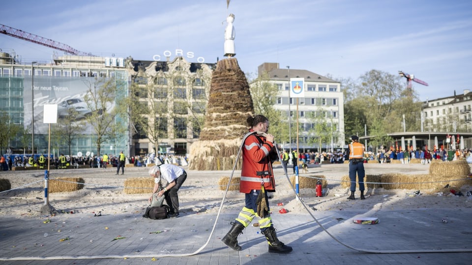Feuerwehrleute bei der Reinigung eines öffentlichen Platzes nach einem Event.
