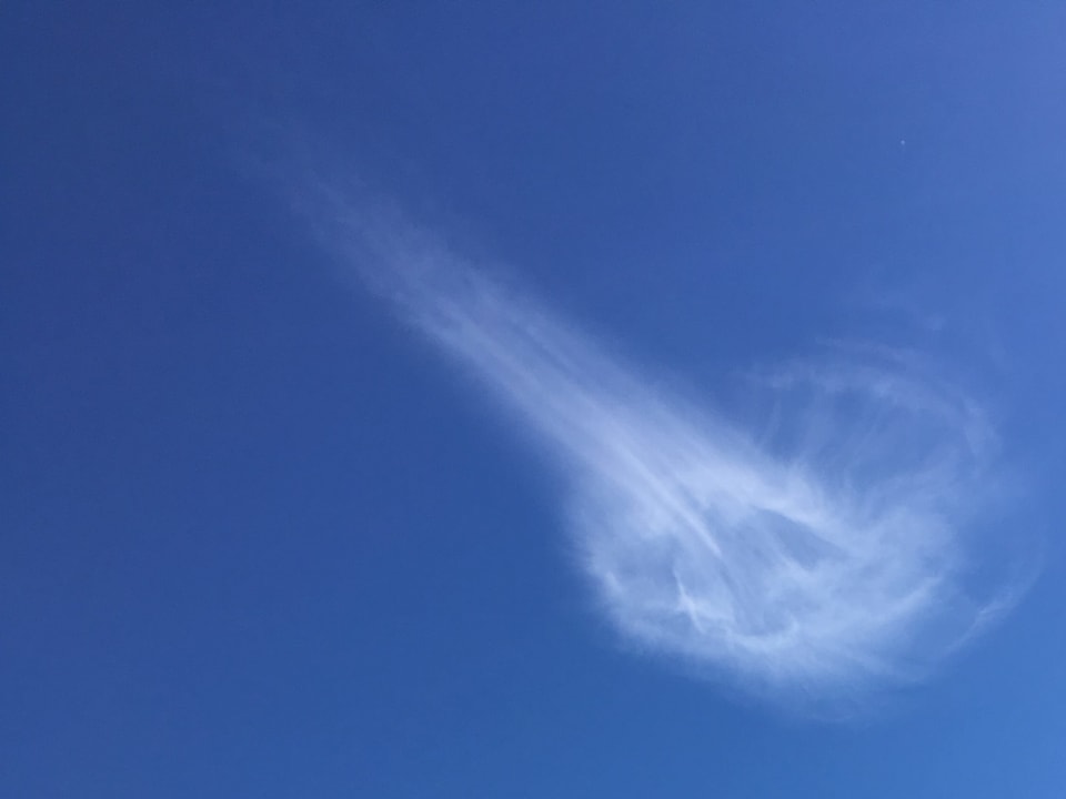 Feine haarähnliche Wolke in Quellen oder Trochterform am blauen Himmel. 