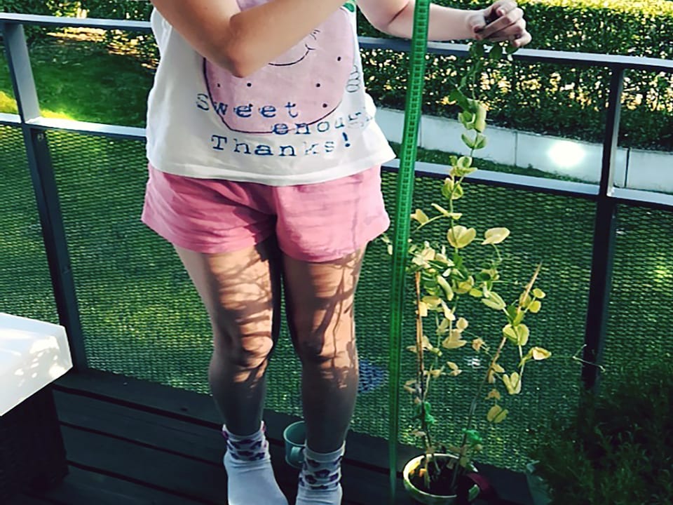 Erbsenpflanze neben einem Mädchen