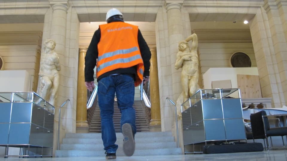 Bauarbeiter in Halle mit Statuen.