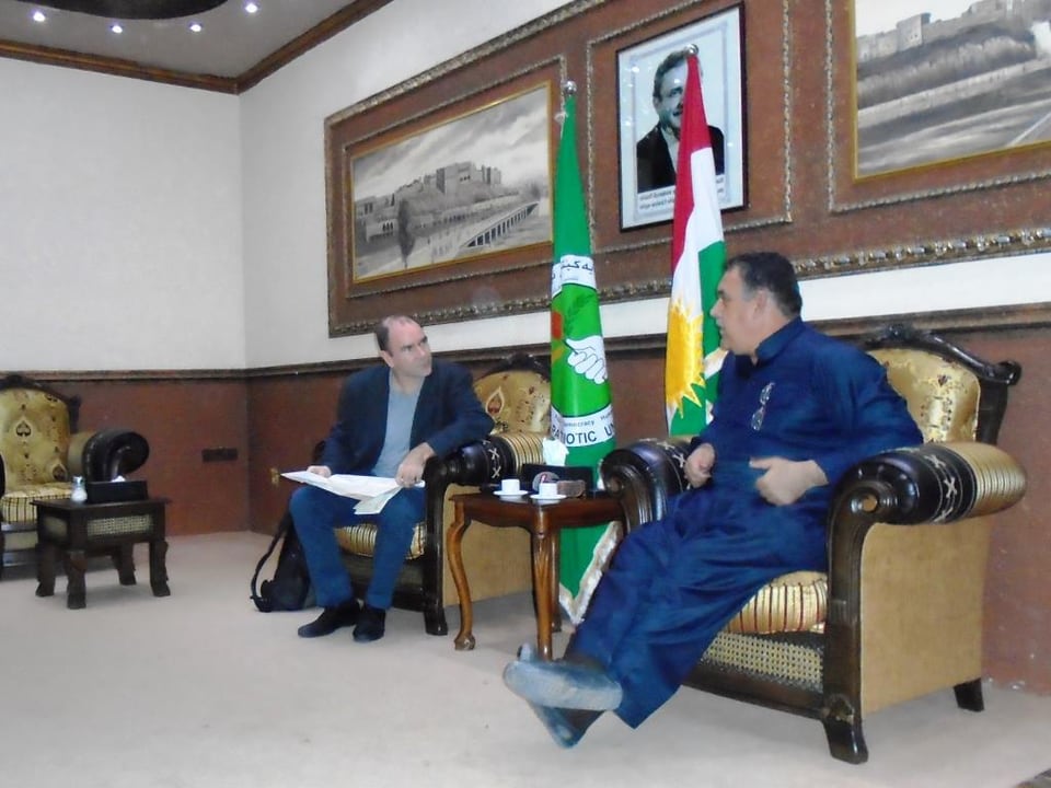 SRF-Korrespondent Philipp Scholkmann und der Kommandant der kurdischen Peschmerga sitzen auf Sesseln in einem offiziellen Empfangszimmer