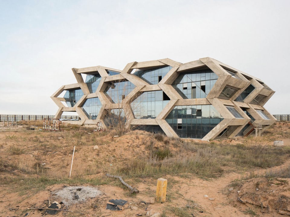 Ein futuristisches Gebäude, umgeben von Wüste.
