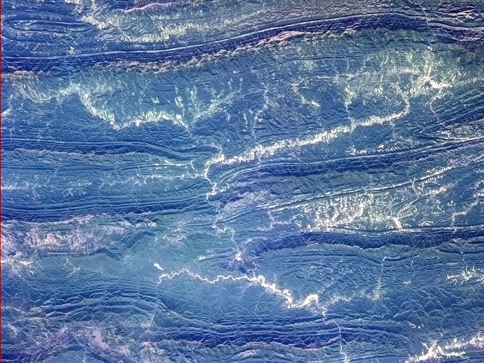 Blick aus dem Orbit auf blau-grün gefärbtes Urwaldgebiet in Südamerika.