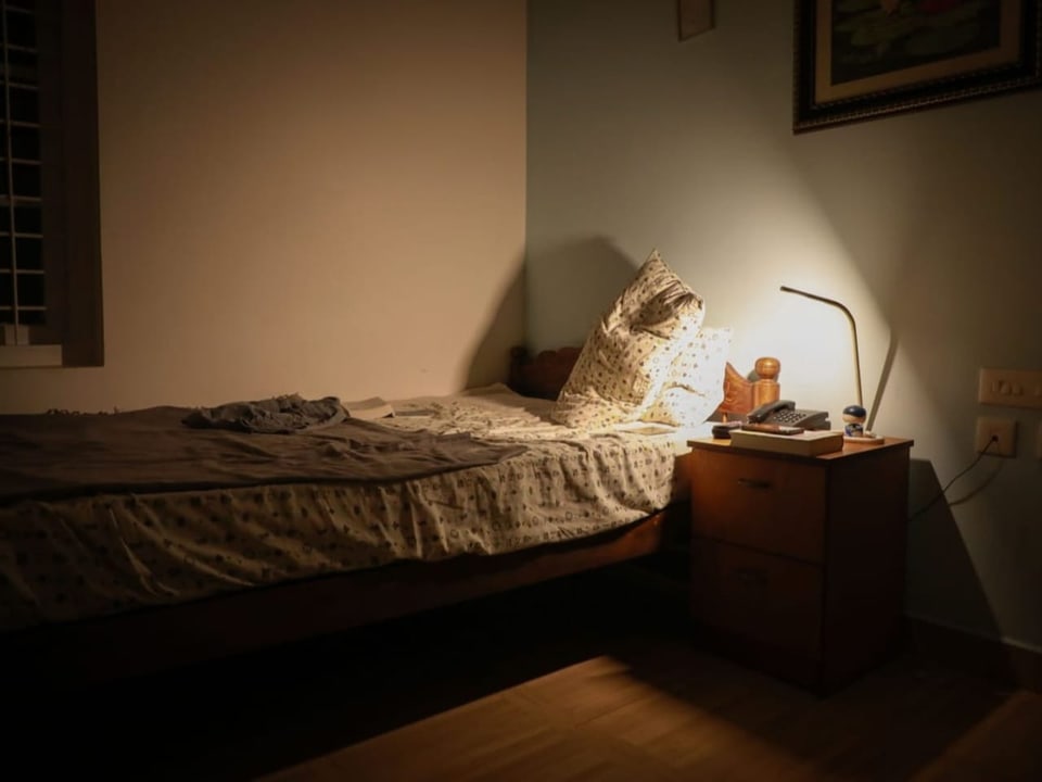 Ein Schlafzimmer, nur erleuchtet von einer Nachttischlampe