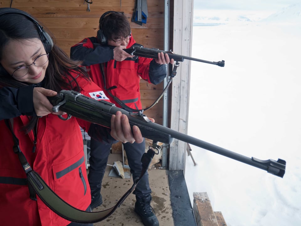 Zwei junge Leute schiessen in der Arktis.