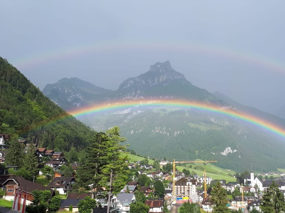 Doppelter Regenbogen über dem Dorf Engelberg mit dem Hahnen im Hintergrund