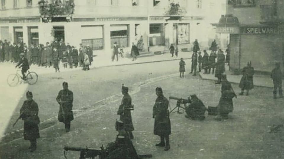 Männer mit Maschinengewehren in Grenchen auf einem öffentlichen Platz. 
