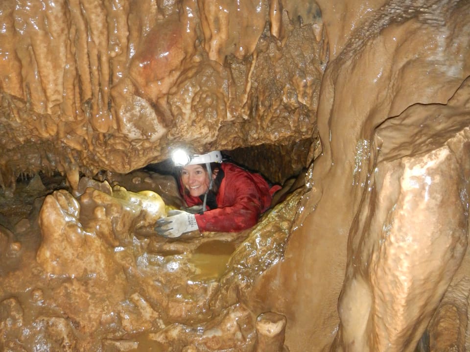Sarah Allemann schaut durch einen hellen Gang in der Tropfsteinhöhle «Malatière» in Frankreich.