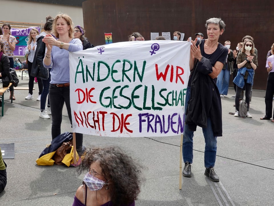 Zwei Frauen mit einem Plakat. 