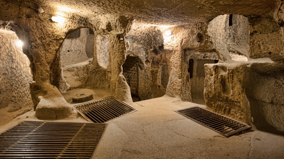 Höhle mit Durchgängen und Treppen und Gitter über Öffnungen auf dem Boden