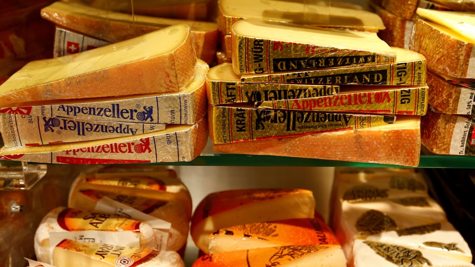 Verschiedene Käsestücke und -sorten in einem Verkaufsregal.