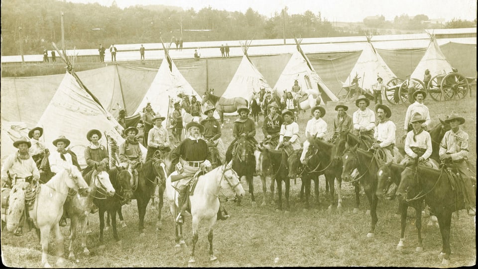 Gruppenfoto von Männern auf Pferden, im Hintergrund Tippis.