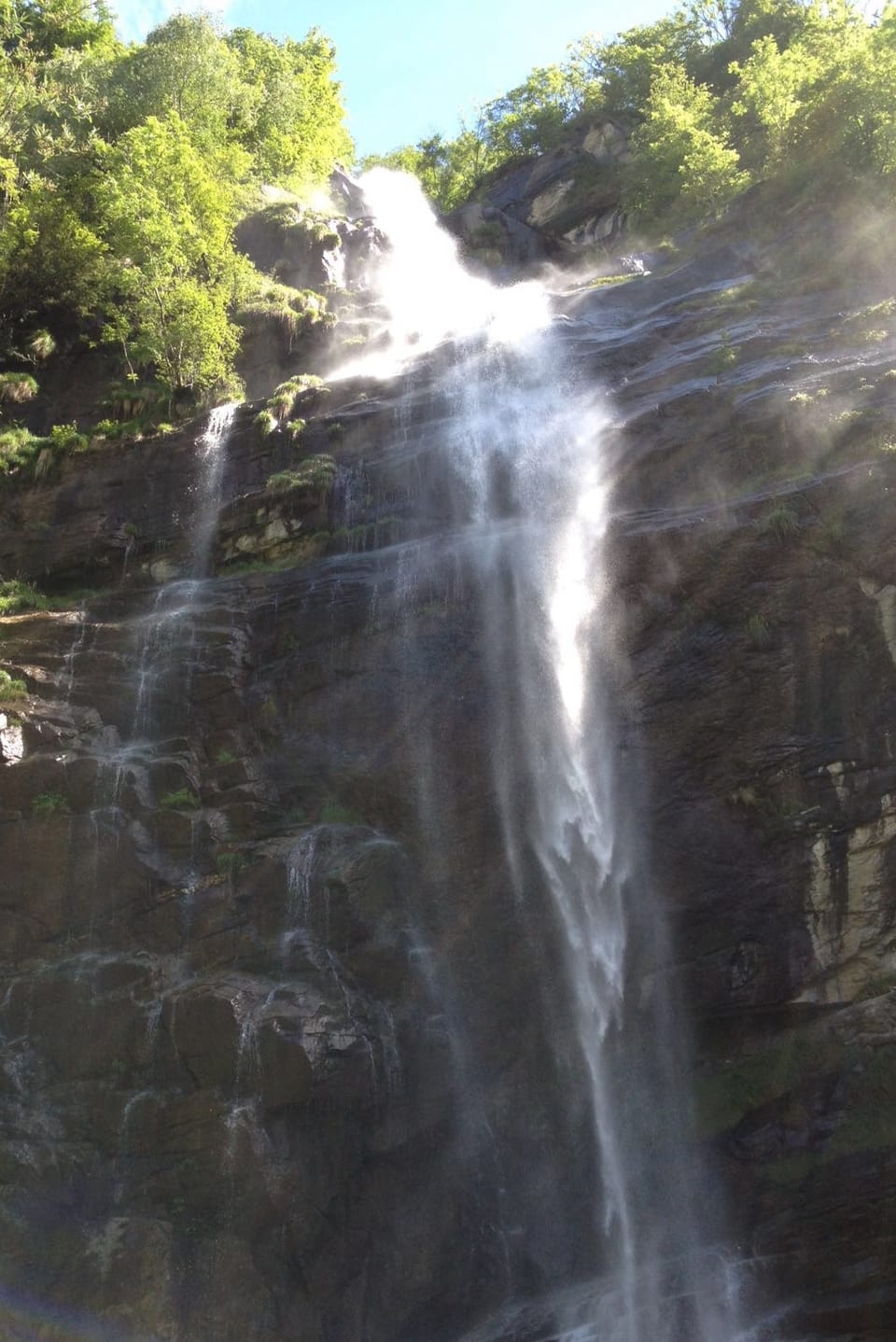 Steile Felswand, am Rand bewaldet, ein eindrücklicher Wasserfall rauscht in die Tiefe.