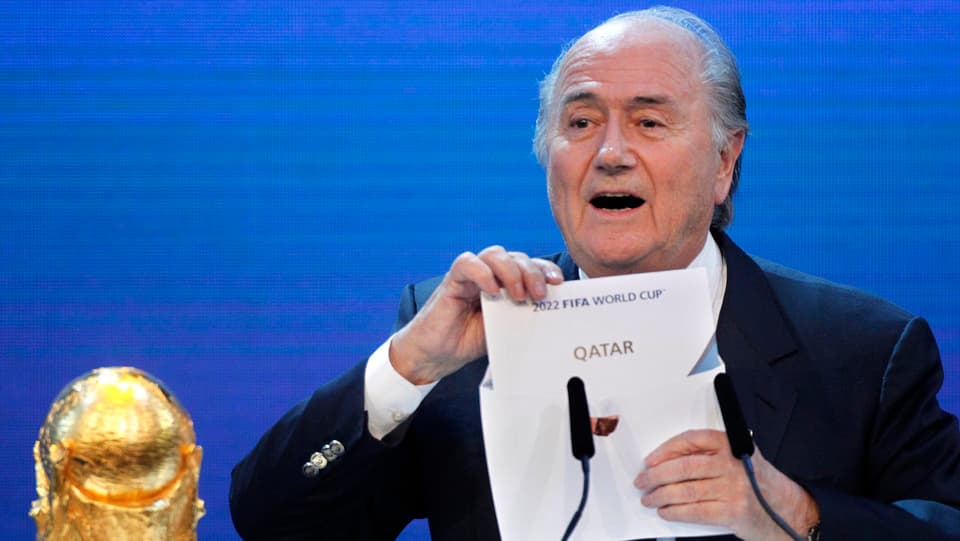Blatter mit dem Zettel «Qatar» in der Hand.