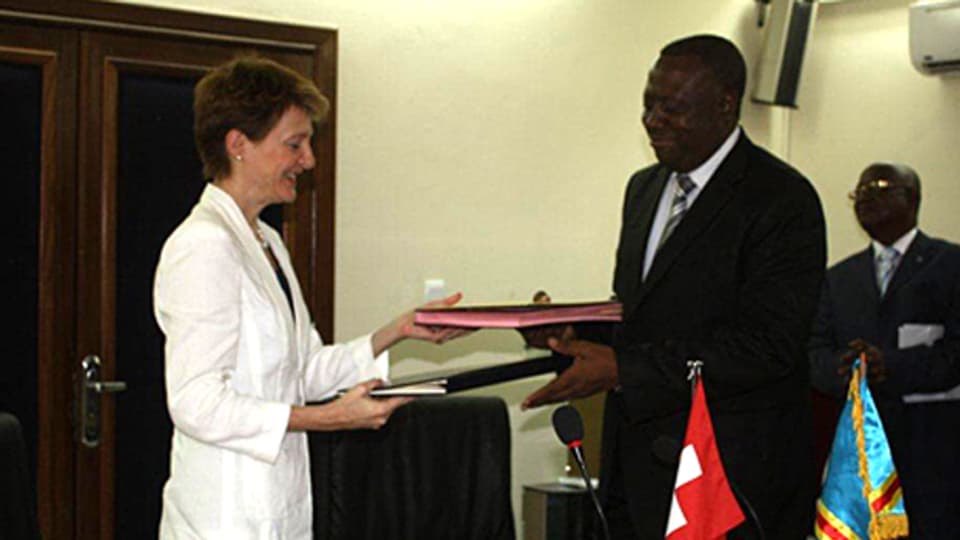 Simonetta Sommaruga und Richard Muyej Mangez mit Dokumenten in den Händen