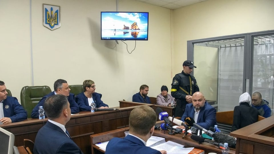 Mehrere Männer sitzen in einem Gerichtssaal in Kiew.