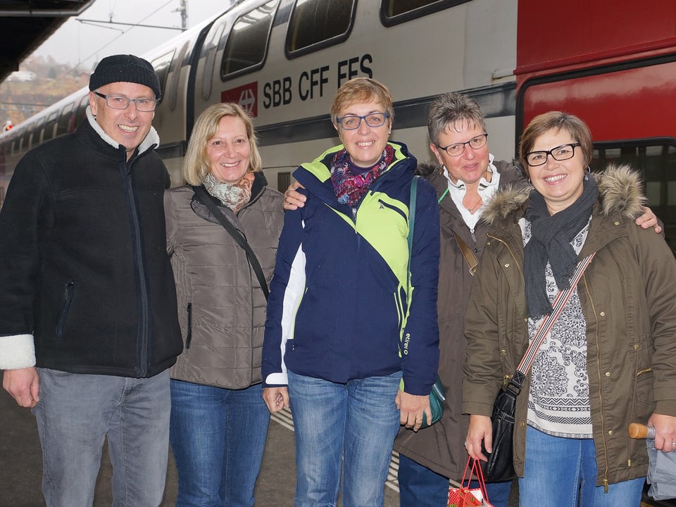Gruppenbild mit einem Mann und vier Frauen vor einem Zugwaggon.