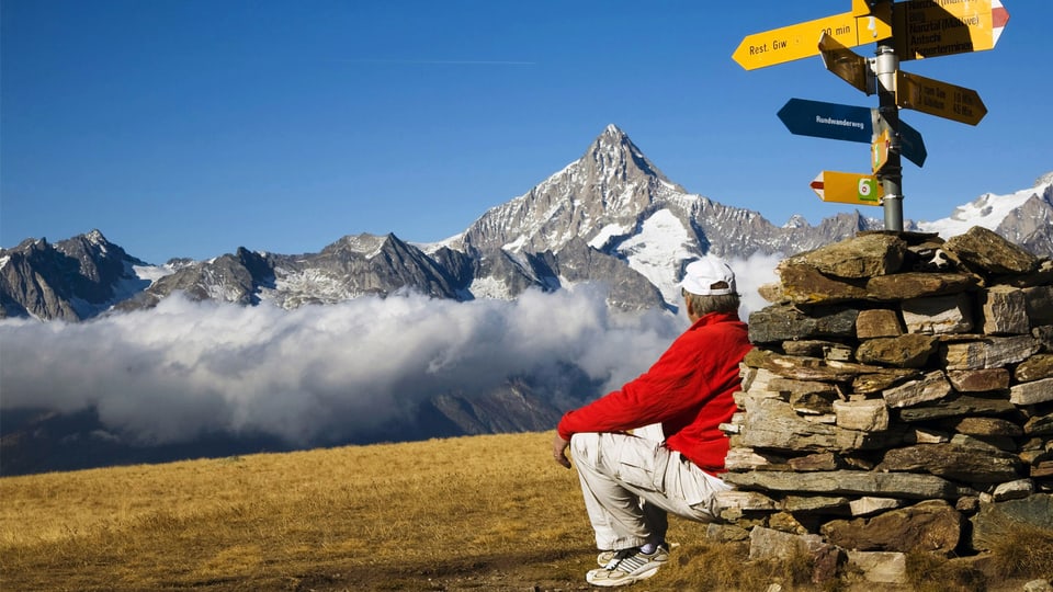 Ein Wanderer bewundert das Walliser Bergpanorama