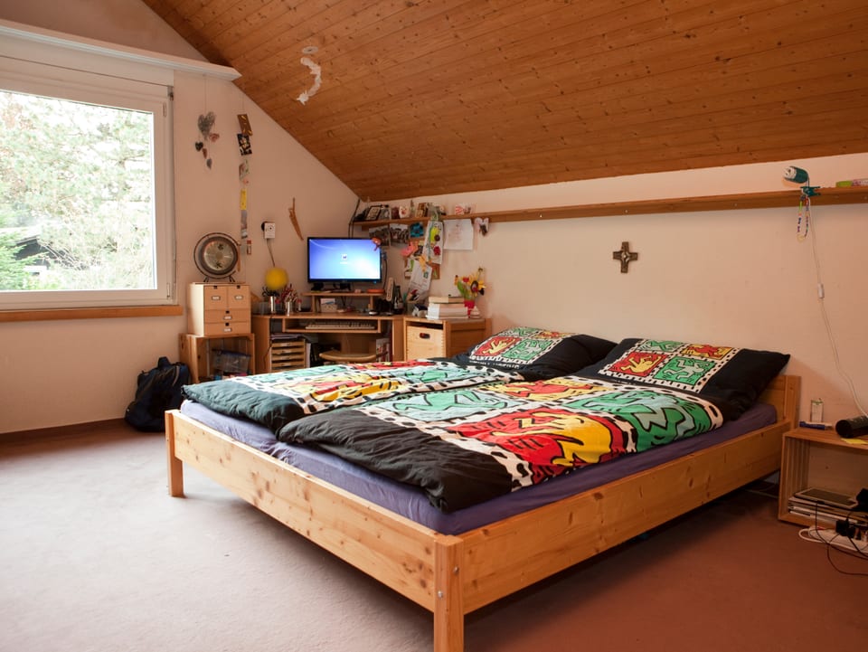Blick ins Schlafzimmer. Doppelbett mit Holzrahmen.