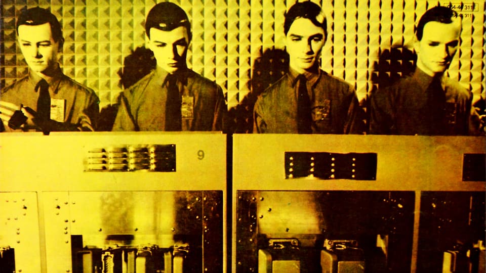 Gelbes Album-Cover: Vier roboterhaft aufgemachte Männer hinter Retro-Computern.