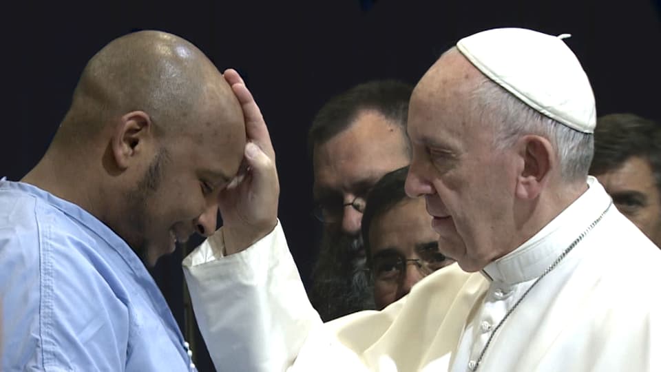 Der Papst segnet einen Mann.
