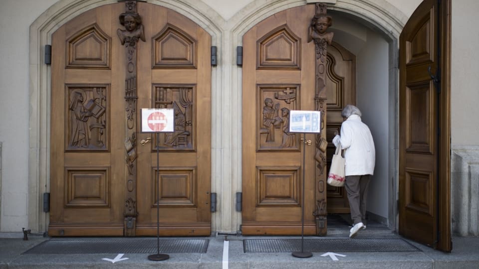 Frau geht durch Kirchentüre