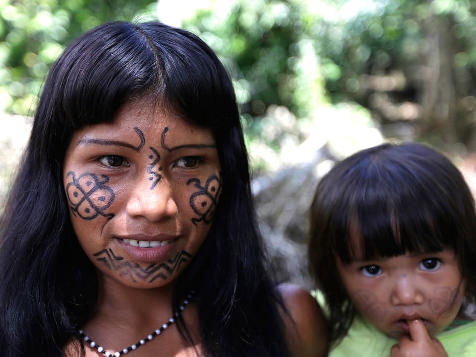 Eine junge Ka’apor-Mutter im brasilianischen Bundesstaat Maranhão mit ihrer Tochter. Die Mutter trägt ornamentartige Tattoos im Gesicht.