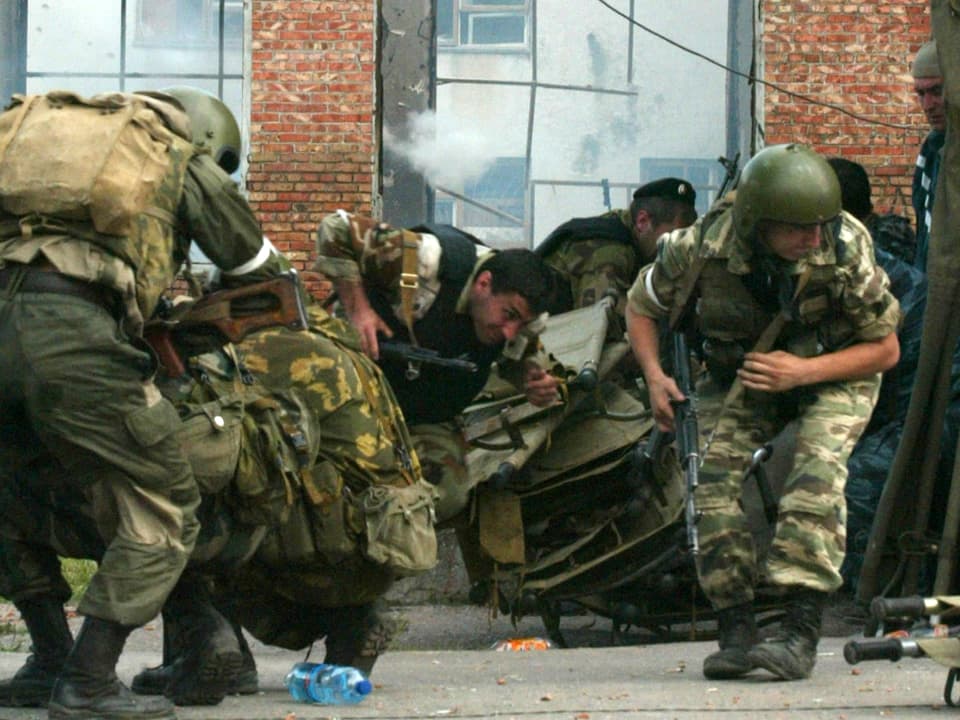 Soldaten rennen vor der Schule herum, Fensterscheiben zerbersten.