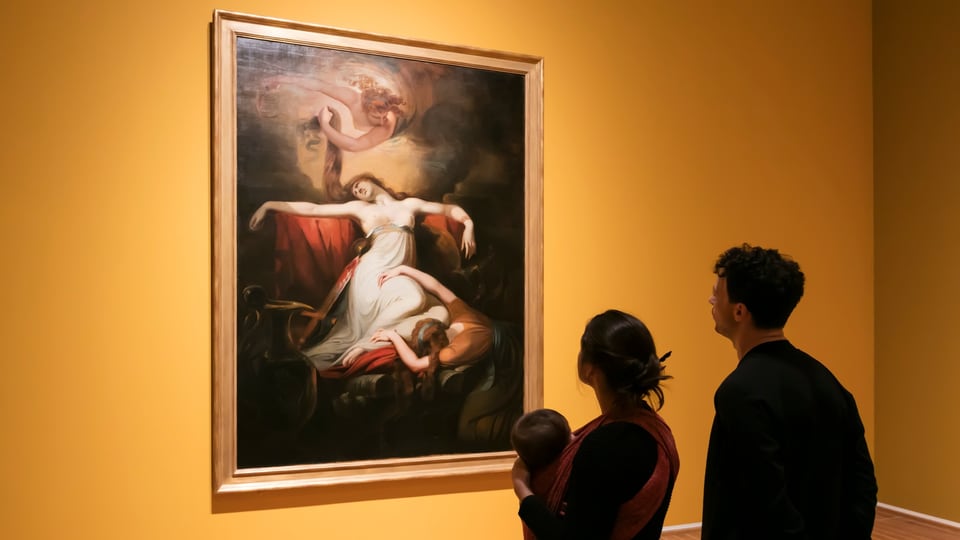 Ein Paar sieht sich ein Gemälde im Museum an