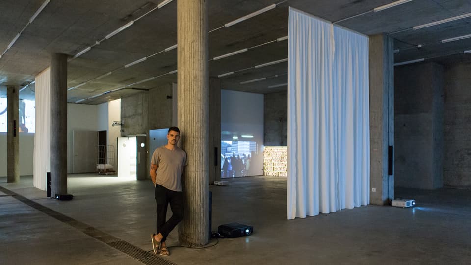 Galerist Jean-Claude Freymond-Gut in einem weitgehend leeren Ausstellungsraum mit Videoinstallationen