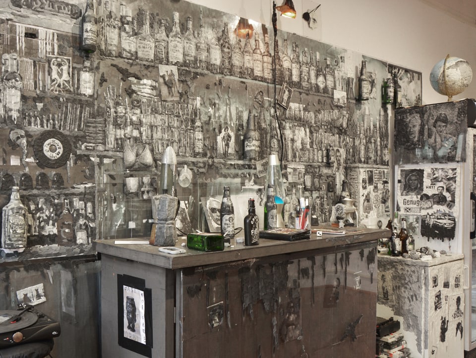 Eine Bar mit Tresen, an der Wand ganz viele verschiedene Fotos und ein Plattenspieler.
