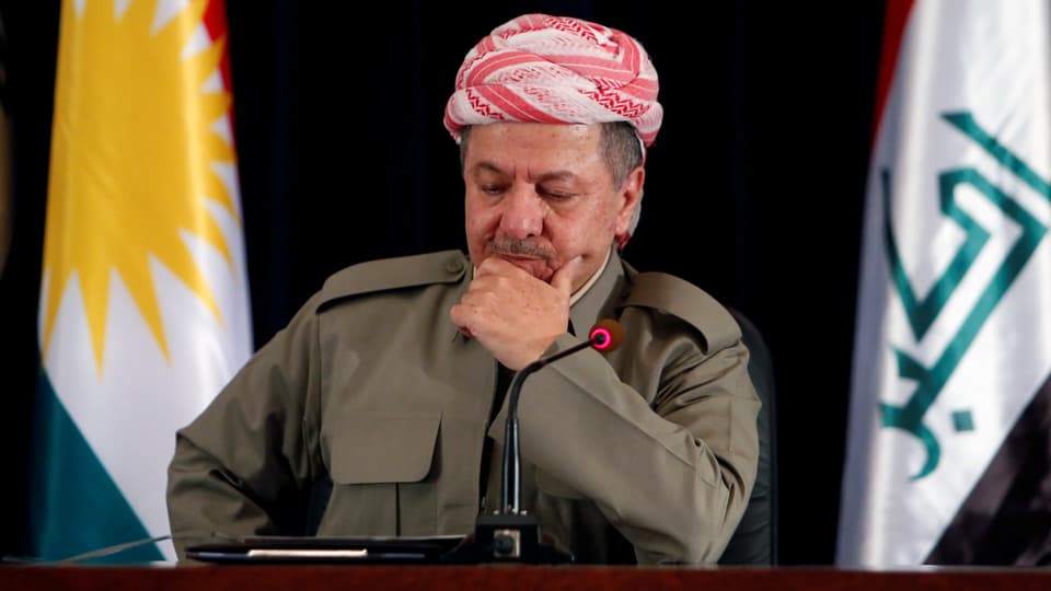 Barsani sitzt mit rot gemustertem Turban und in Uniform vor einem Mikrofon.
