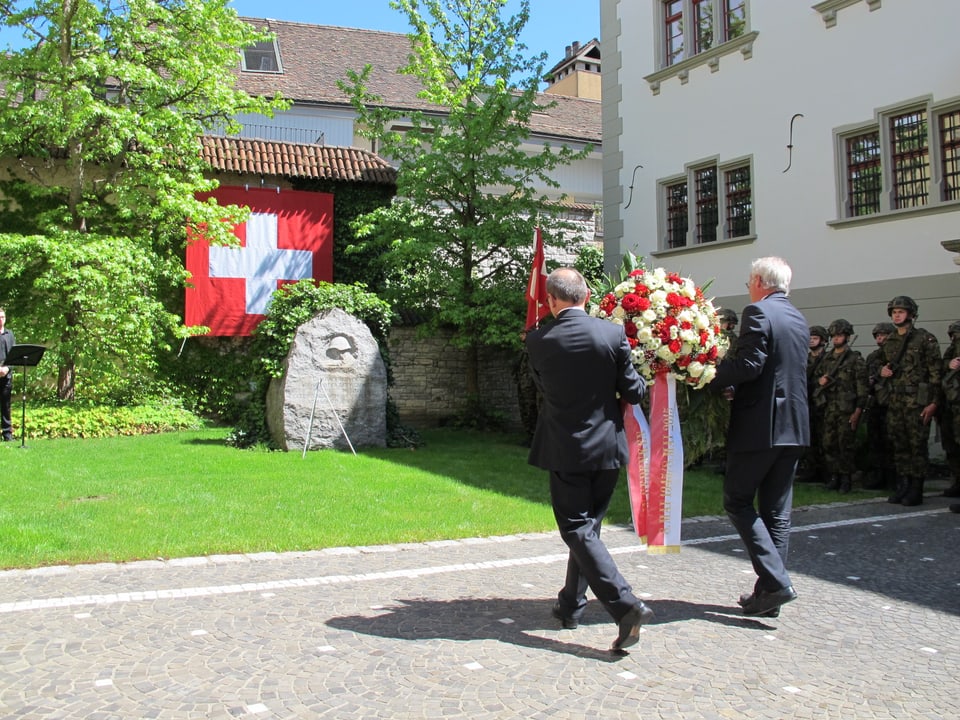 Regierungsratspräsident Ernst Landolt (links) und Vize-Präsident Reto Dubach legen beim Soldatendenkmal einen Kranz nieder.